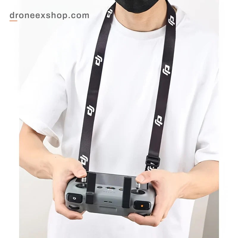 Pilot wearing the neck strap while holding a DJI RC controller